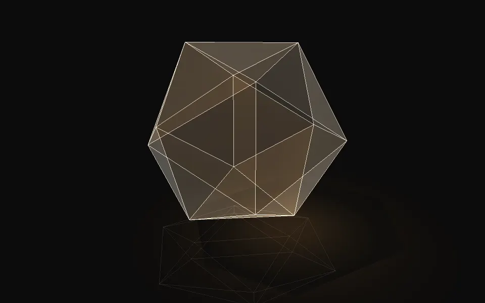 A glass icosahedron on a desk under a lamp